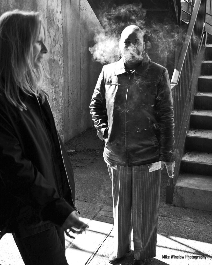 2 women smoking in a stairwell